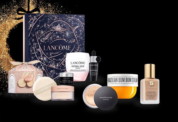 Aveda, Number 7, Estee Lauder and Sol de Janeiro products beside a gold glittery bauble on a black background